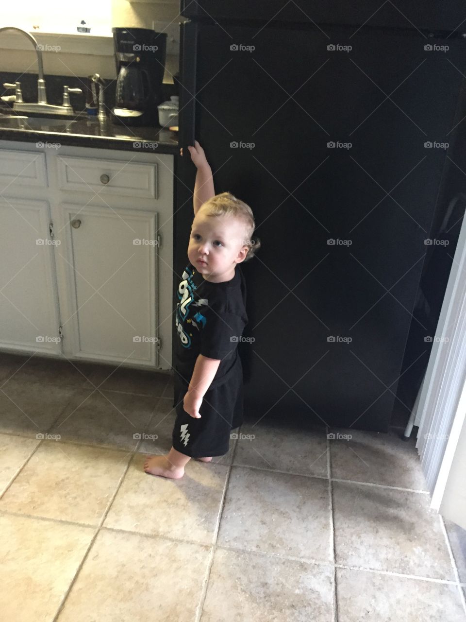 Baby standing in kitchen