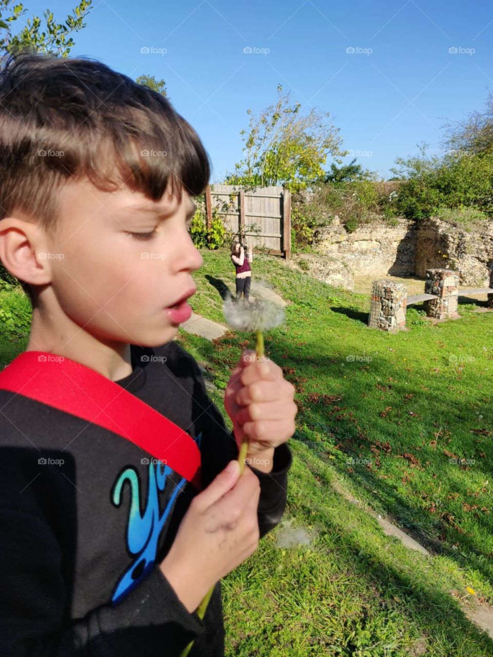 Boy blowing a dandelion