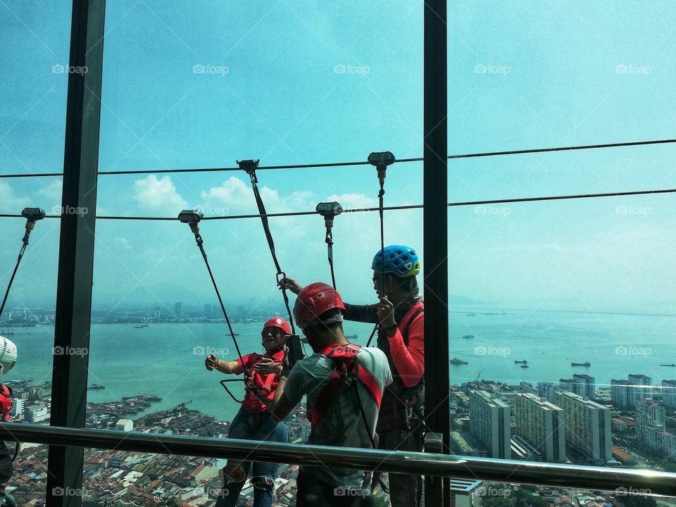 Boys harnessed outside THE TOP Tower in Penang Malaysia