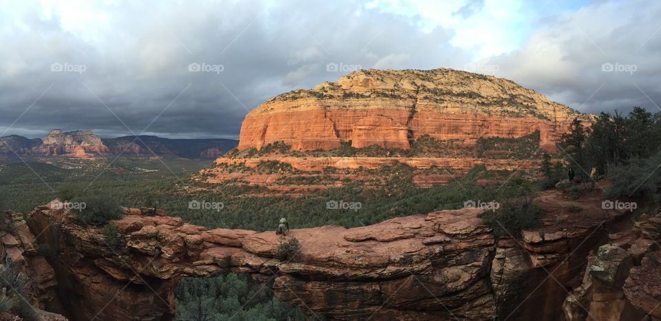 Partial panorama of a Devil's Bridge in Sedona, Arizona. Hiker pictured on the rocks.