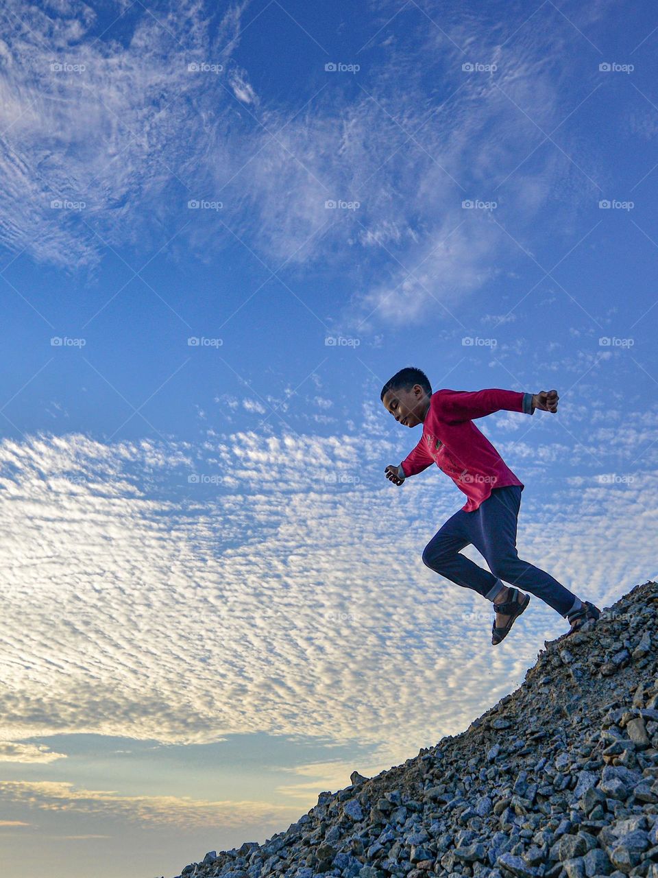 A boy doing a downhill run against the morning sky