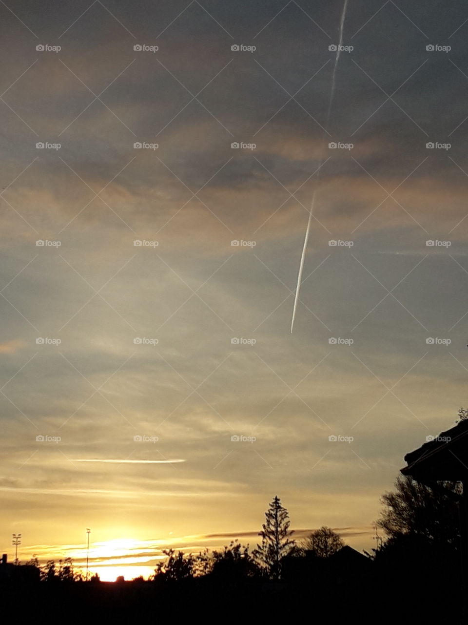 golden sunset with  airplane  trace on sky