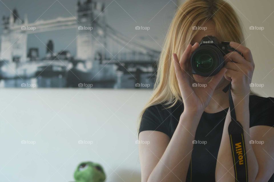 Blonde woman taking photo with Nikon Camera