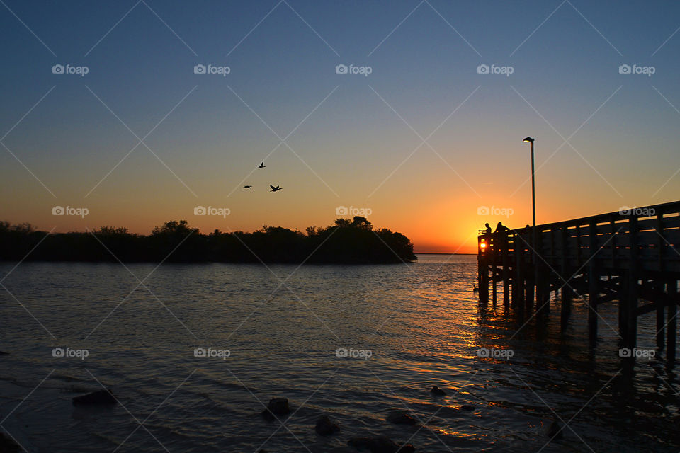 People fishing at sunset on pier