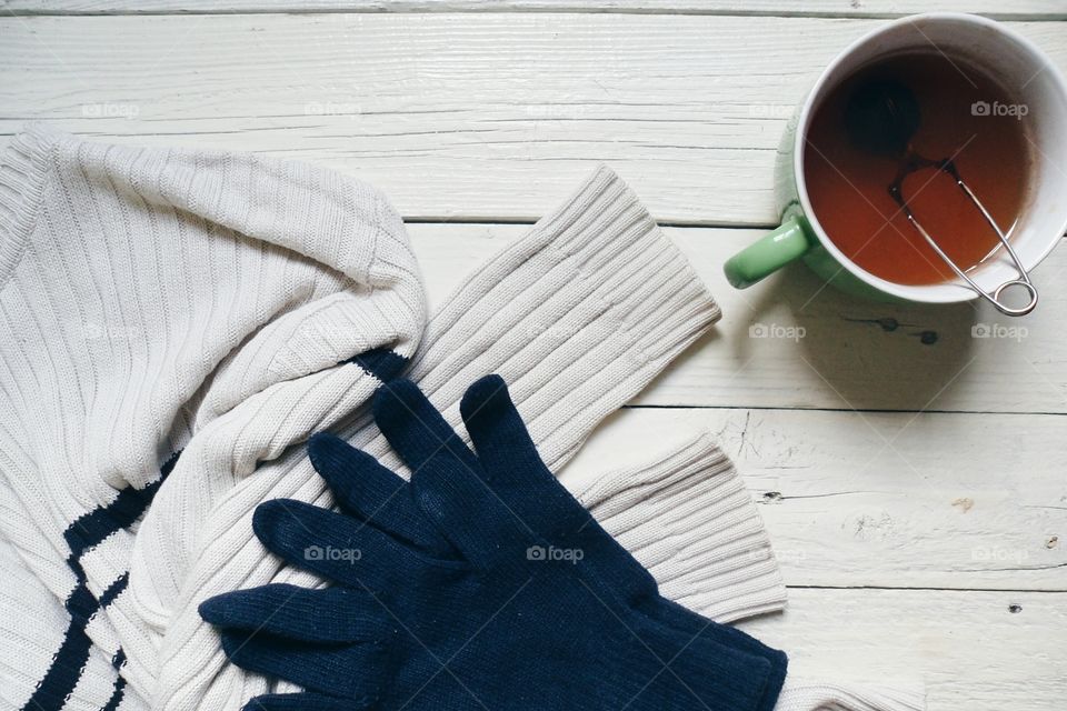 Cup of tea and warm clothing on the table