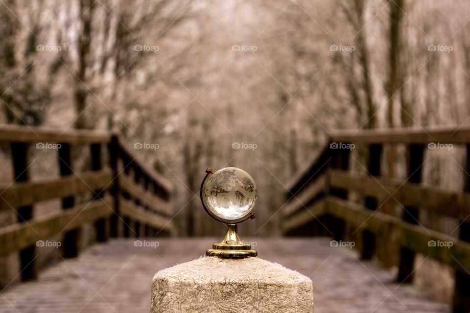 Little glass globe in the path of a wooden bridge