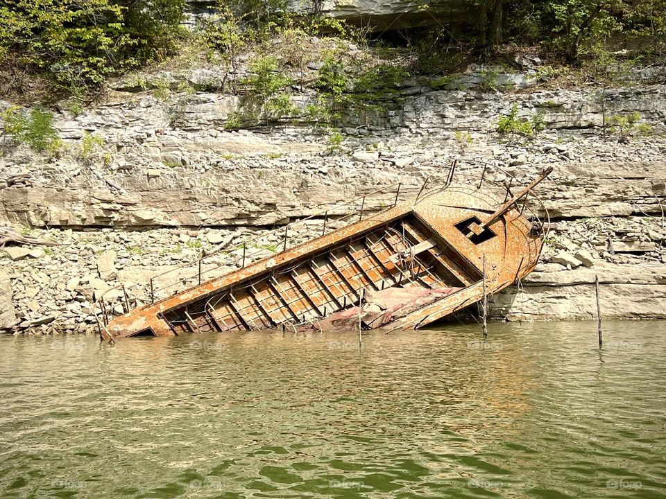 Old abandoned boat that is usually underwater until the lake levels are lowered for winter in Kentucky 