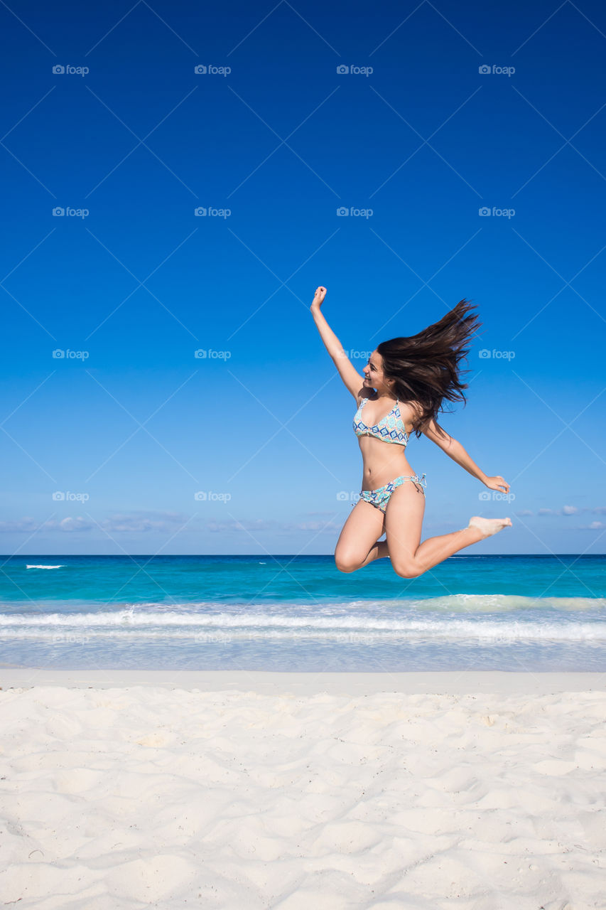 Beautiful girl jumping in the beach 