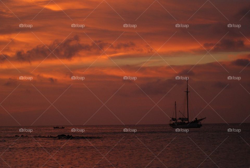 Silhouette of sailboat at sunset