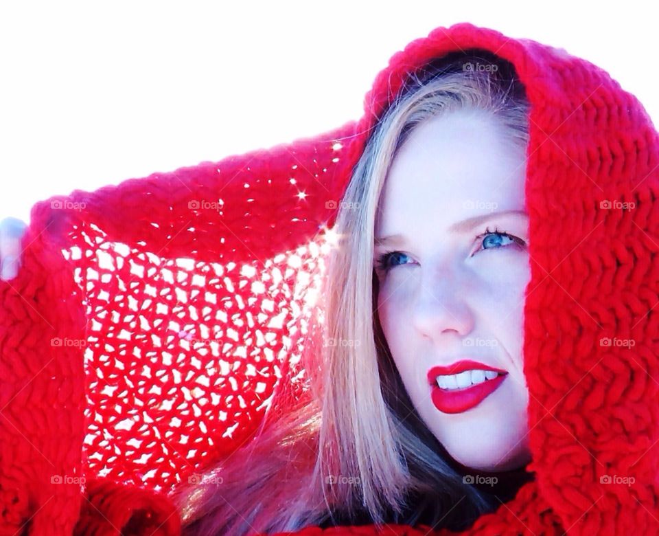 Backlit by beautiful winter sunshine. Blue eyed woman in red scarf. 