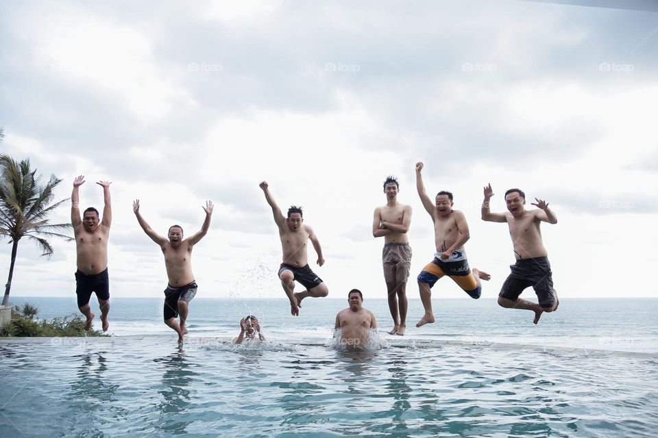 Summer has arrived, it's time for vacation., a group of people are swimming in the swimming pool at parangtritis beach in the summer in the afternoon when the sun is hot