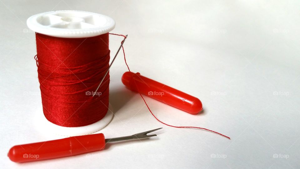 Red sewing thread and seam ripper