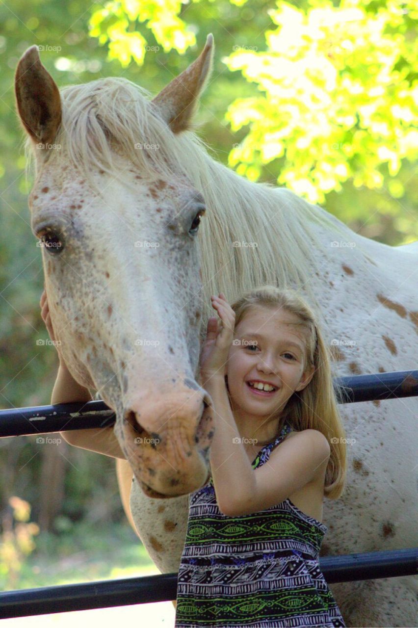 Close-up of little girl with horse