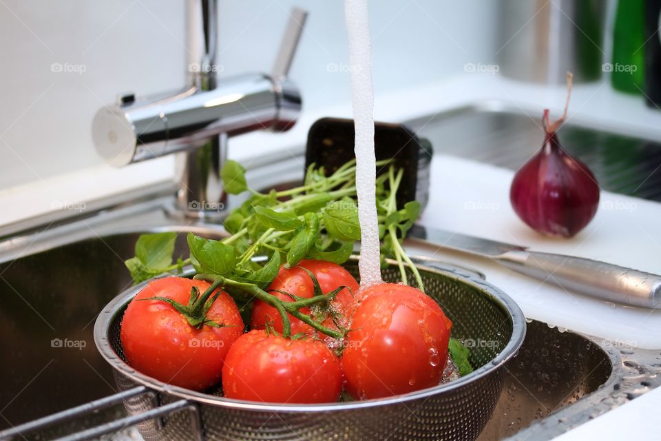 Colander with tomatoes in a sink