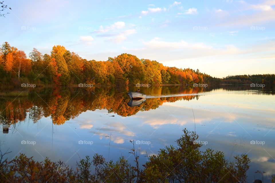 Autumn boat and a fisherman