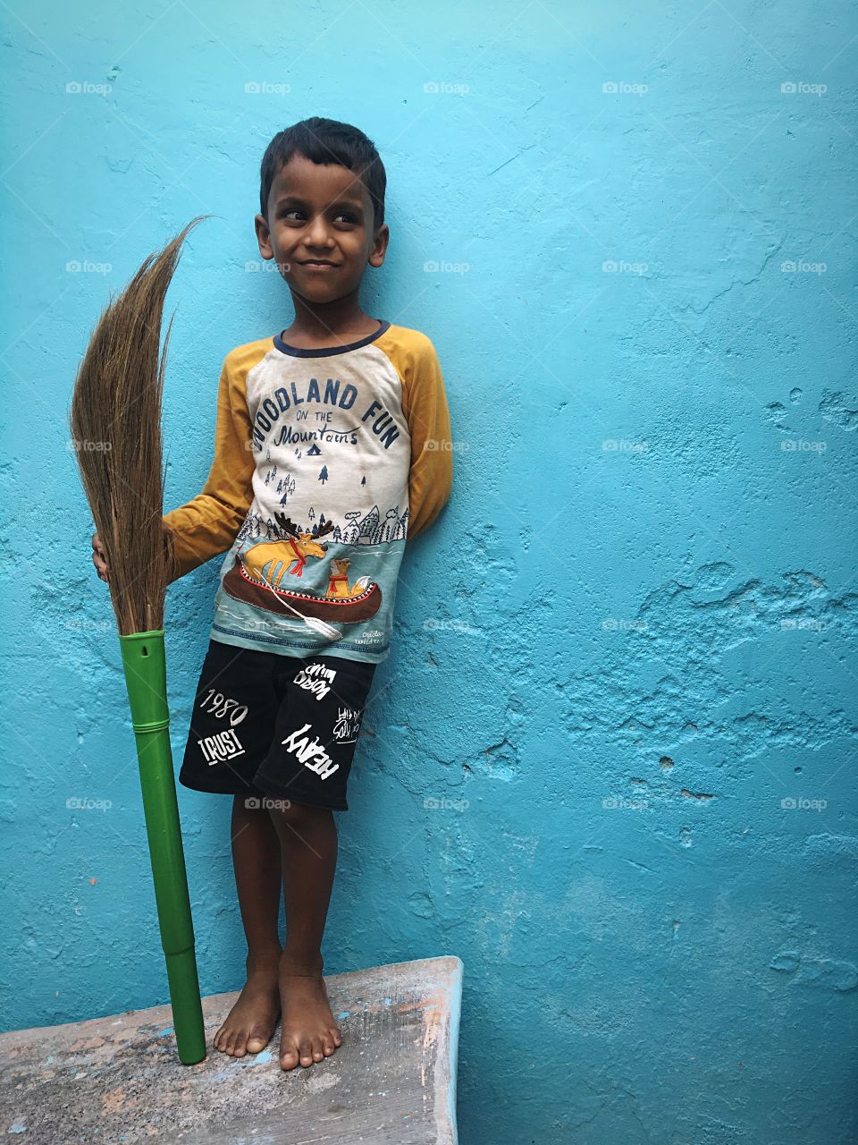 Portrait of a little kid with a broom stick 