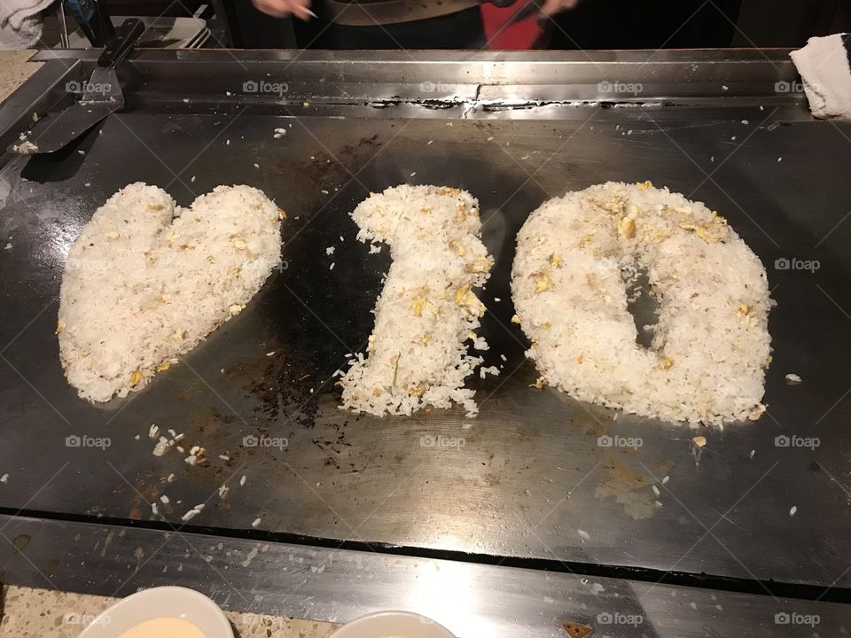 A heart and the #10 made out of fried rice on a grill 