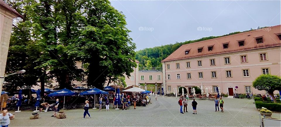 This is the courtyard of “Weltenburg Abbey” in “Bavaria” by the “Danube Gorge” or “Weltenburg Narrows” with an outside beer garden under sun umbrellas. The beer produced in the abbey brewery has won numerous awards. 2024. Hypnotic Productions
