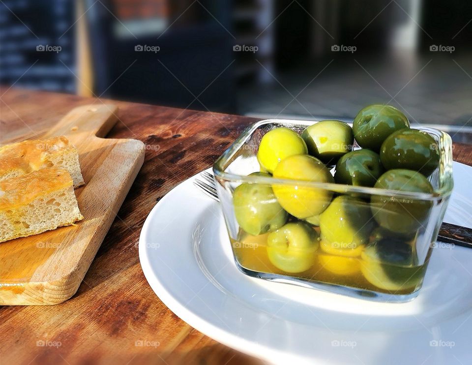 Olives and bread on a table at a restaurant