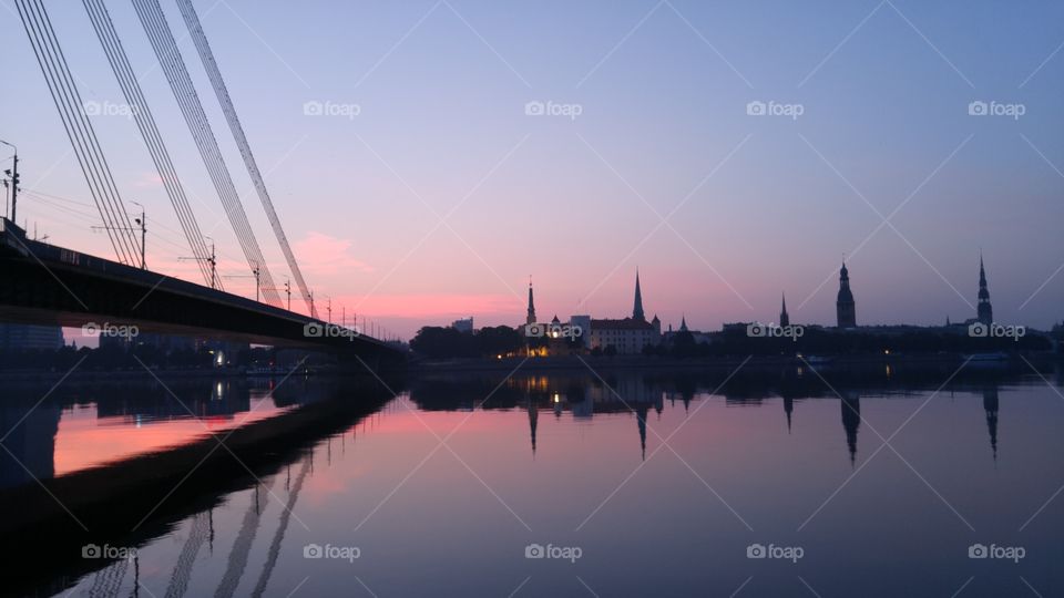 A beautiful sunset over city panorama with river and bridge in Riga, Latvia