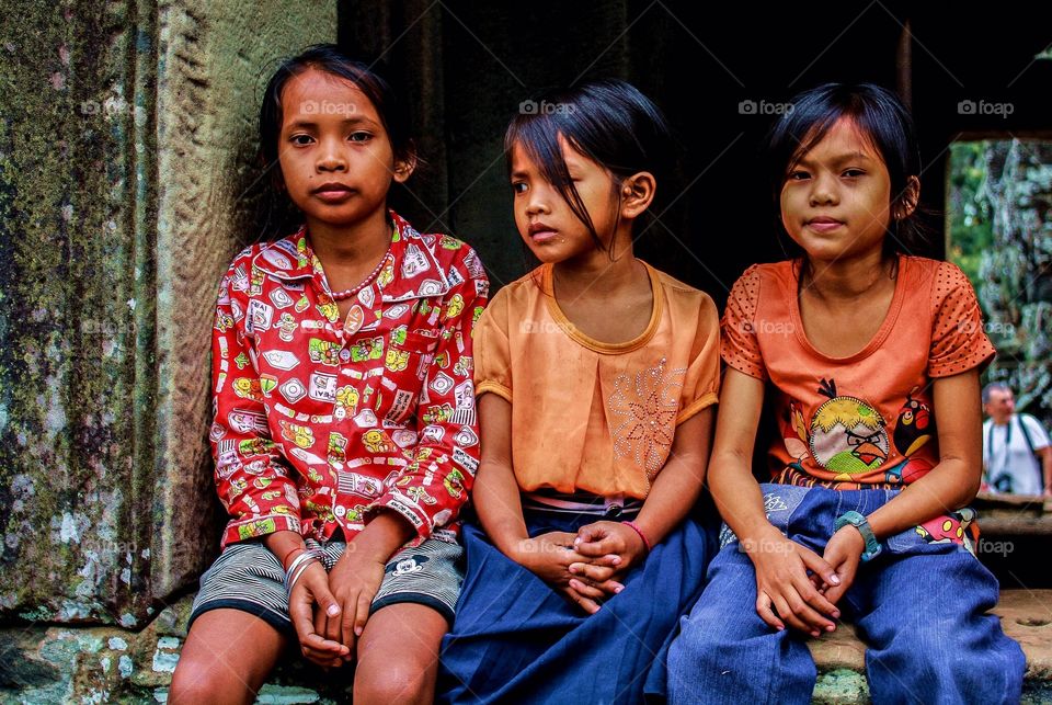 Children of Angkor. I was wandering through the temples of Angkor when I saw these three sitting in a window.