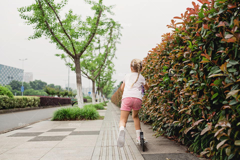 Little girl riding on scooter 