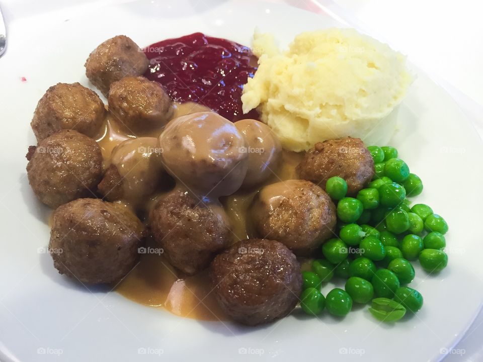 Swedish traditional dish, meatballs, mashed potatoes, peas, lingonberry jam and gravy.