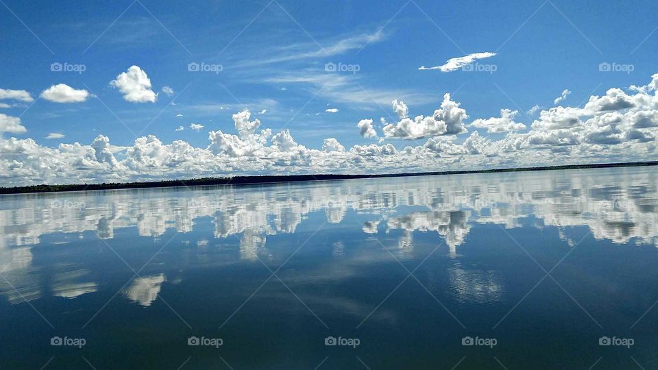 Uma paisagem de águas com o céu azul nublado.