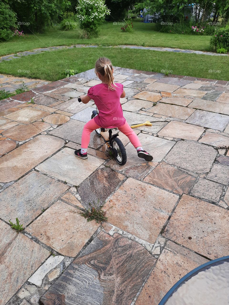 kids bicycle - litlle girl  on a walking bike on a terrace