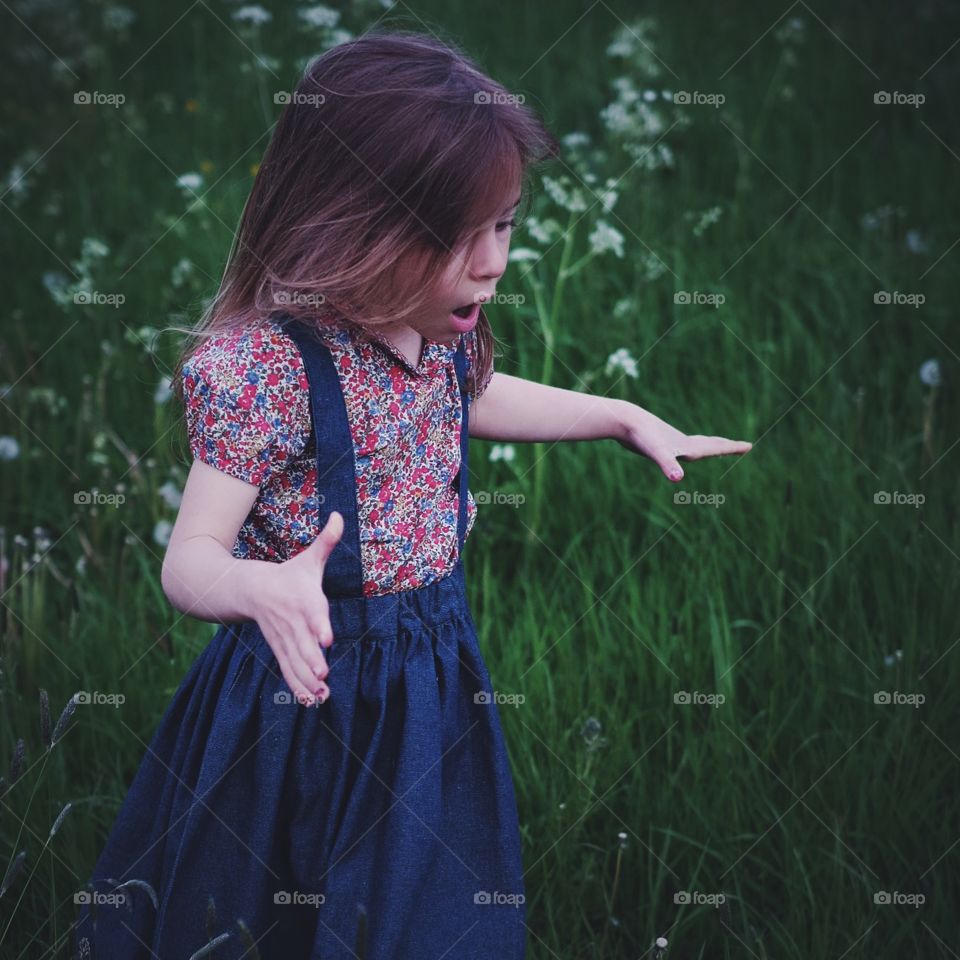 Surprise!. Lucy's look of delight at discovering a huge patch of dandelions ready to blow and make wishes.