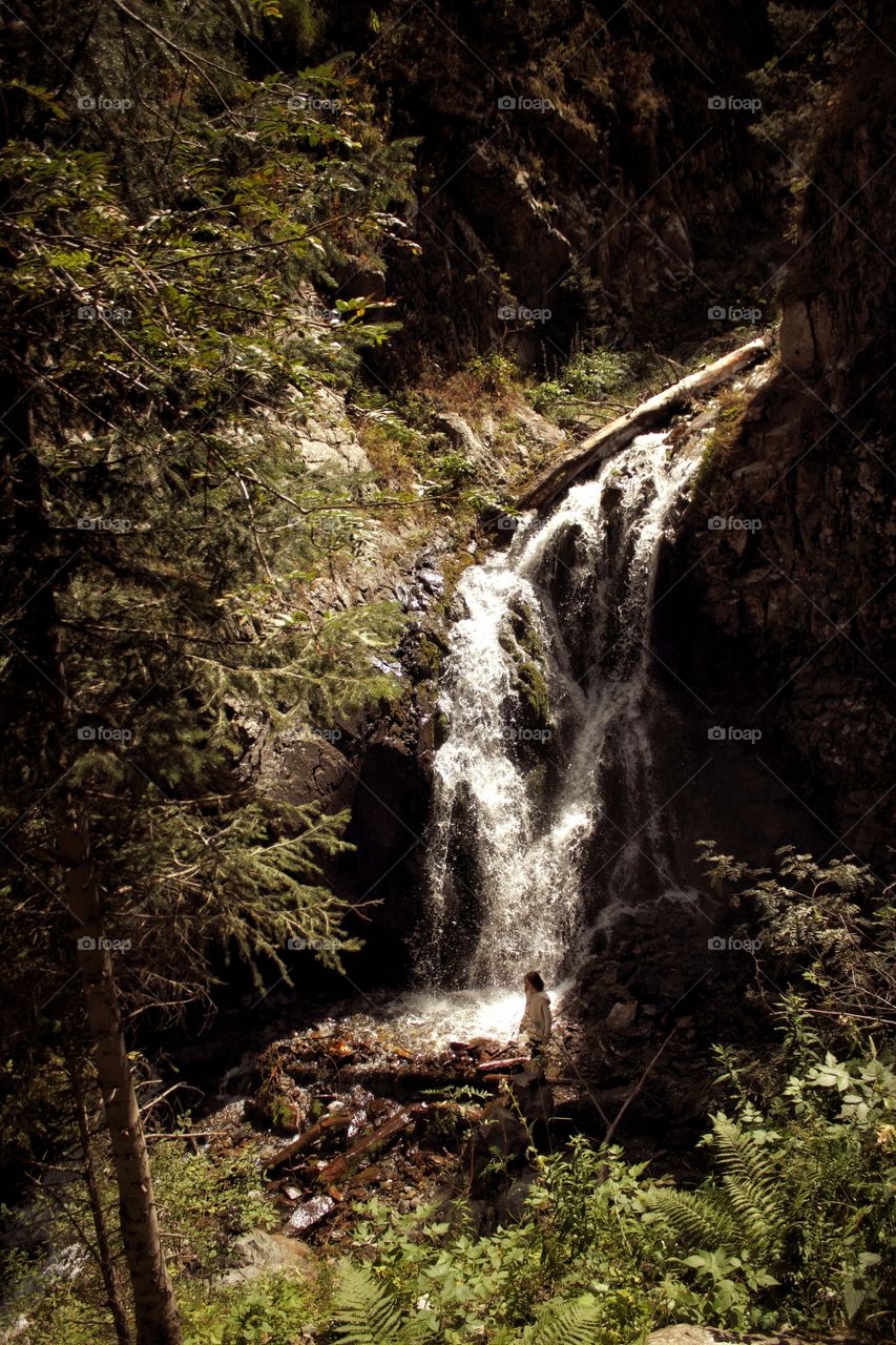 Girl at the mountain waterfall