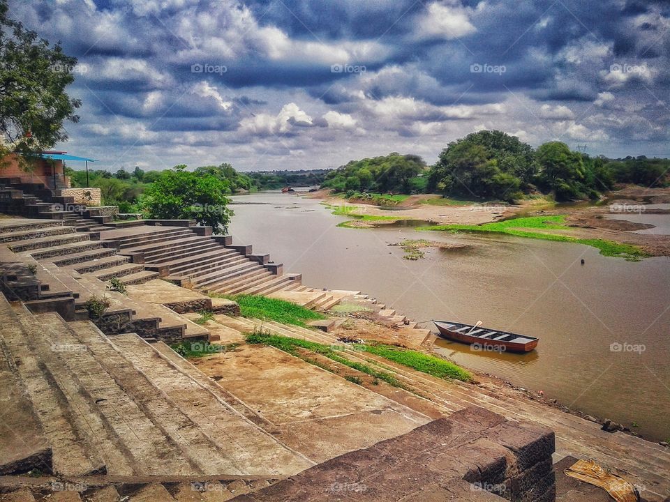 Bank of River with stairs, boat and surrounding nature.