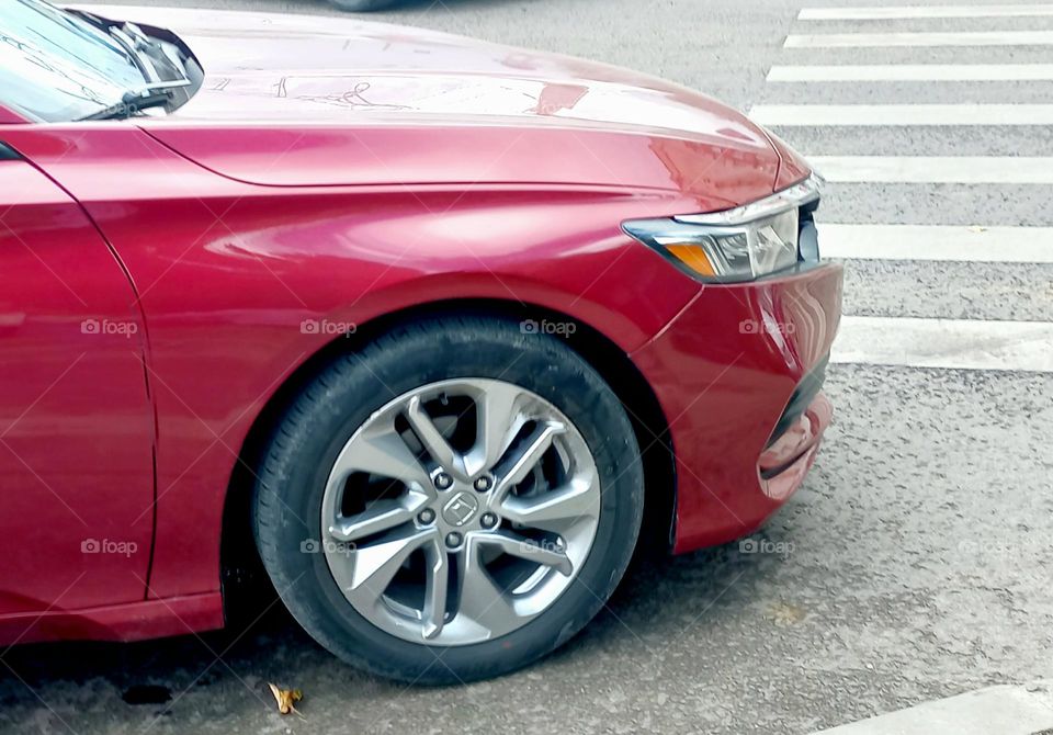 front of a dark red car.