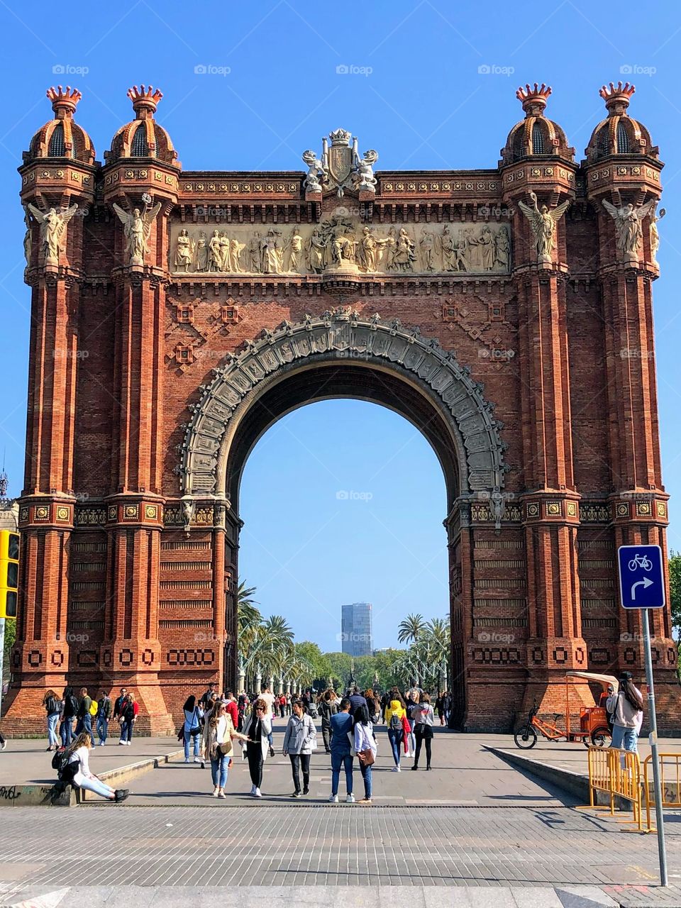 View to the red colour patterned Arc de Triomf triumphal arch in the public park in Barcelona