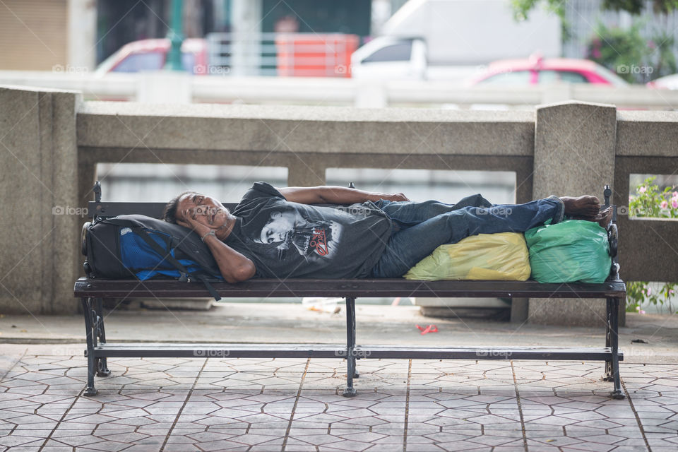 Homeless people sleeping in the public chair in Bangkok Thailand 