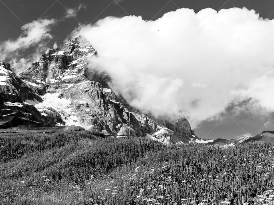 Clouds on the top of mountain peak , black and white 