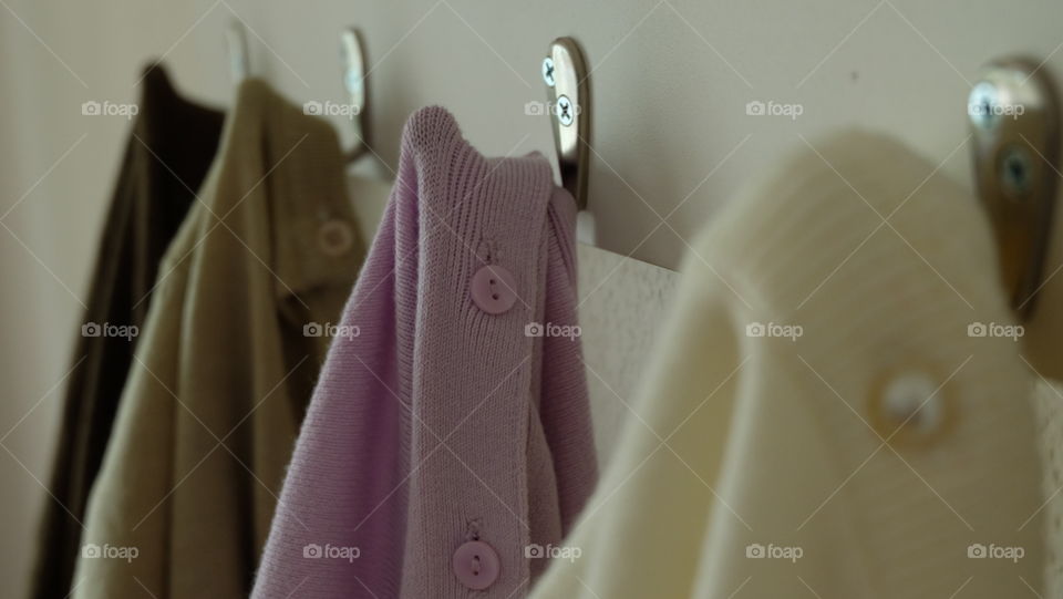 Sweaters hanging from hooks