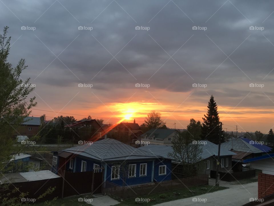 Sunset on a cloudy sky.  Sunset over the one-story house.