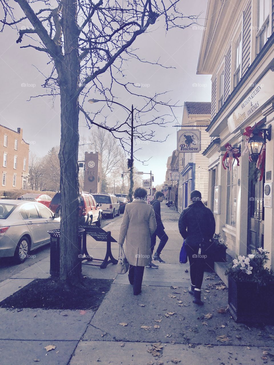 Rear view of people walking on sidewalk