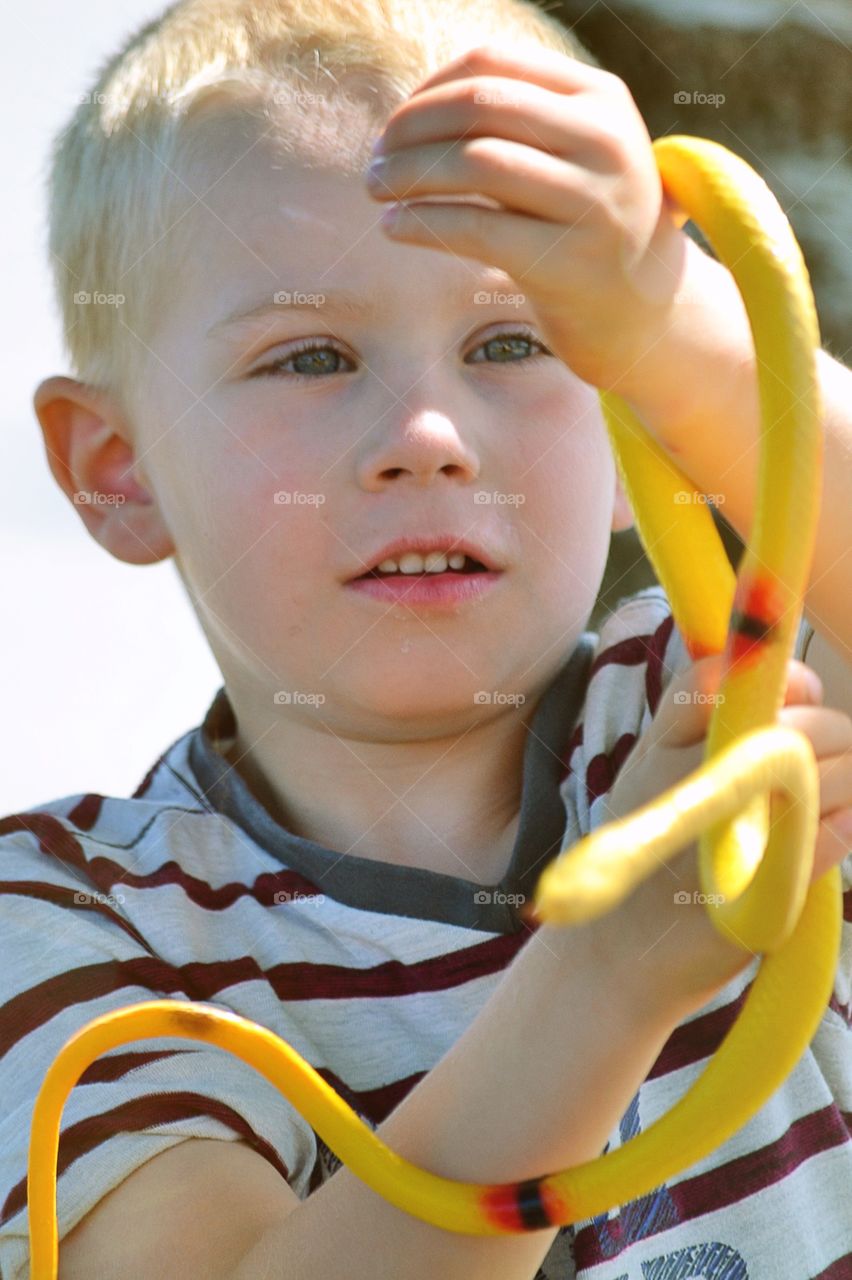 Boy playing with a toy snake