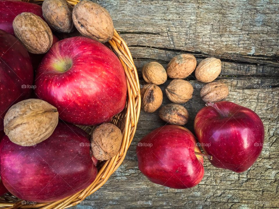 Wooden basket full of red appples and nuts