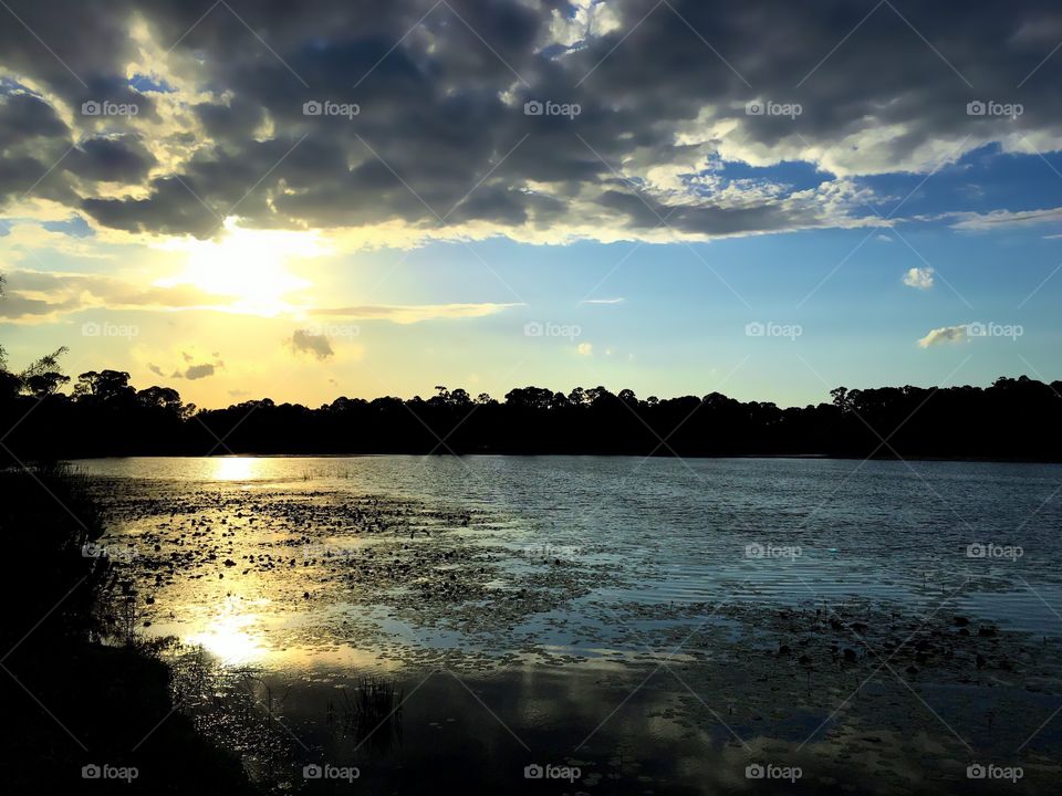 Clouds and sun reflecting in river