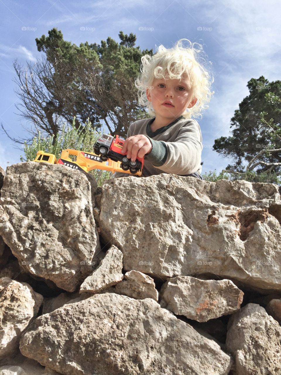 Boy playing on a stone wall 