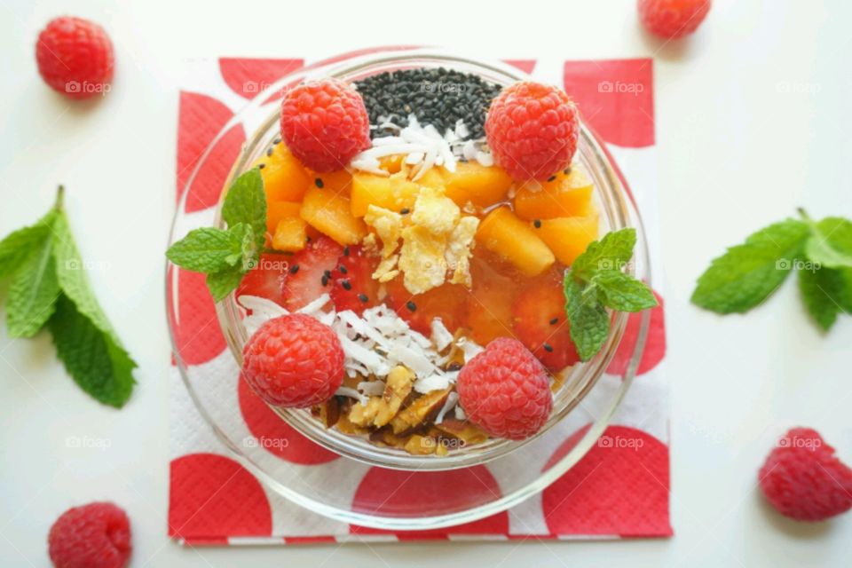 Smoothie fresh fruits bowl - peach, raspberry,  almonds,  strawberries,  coconut,  honey,  seeds and mints