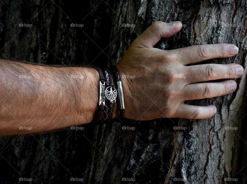 A man hiking, leaning on a tree