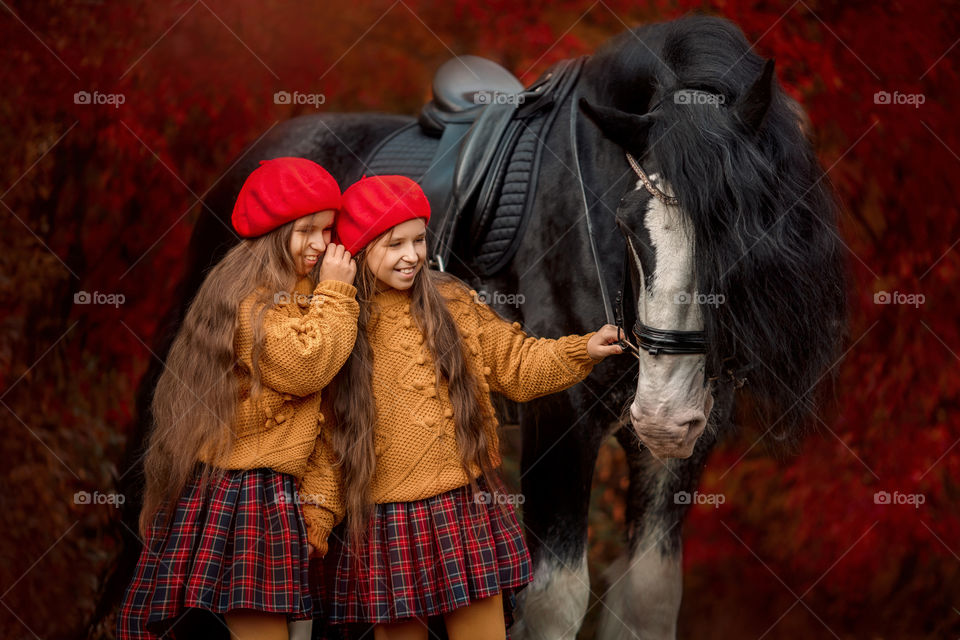 Twins girls with black claydasdale stallion 