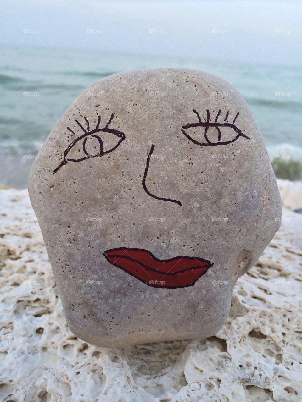 Stone face with red lips 