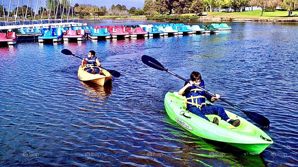 Paddling a boat around the lake with friends is fun!