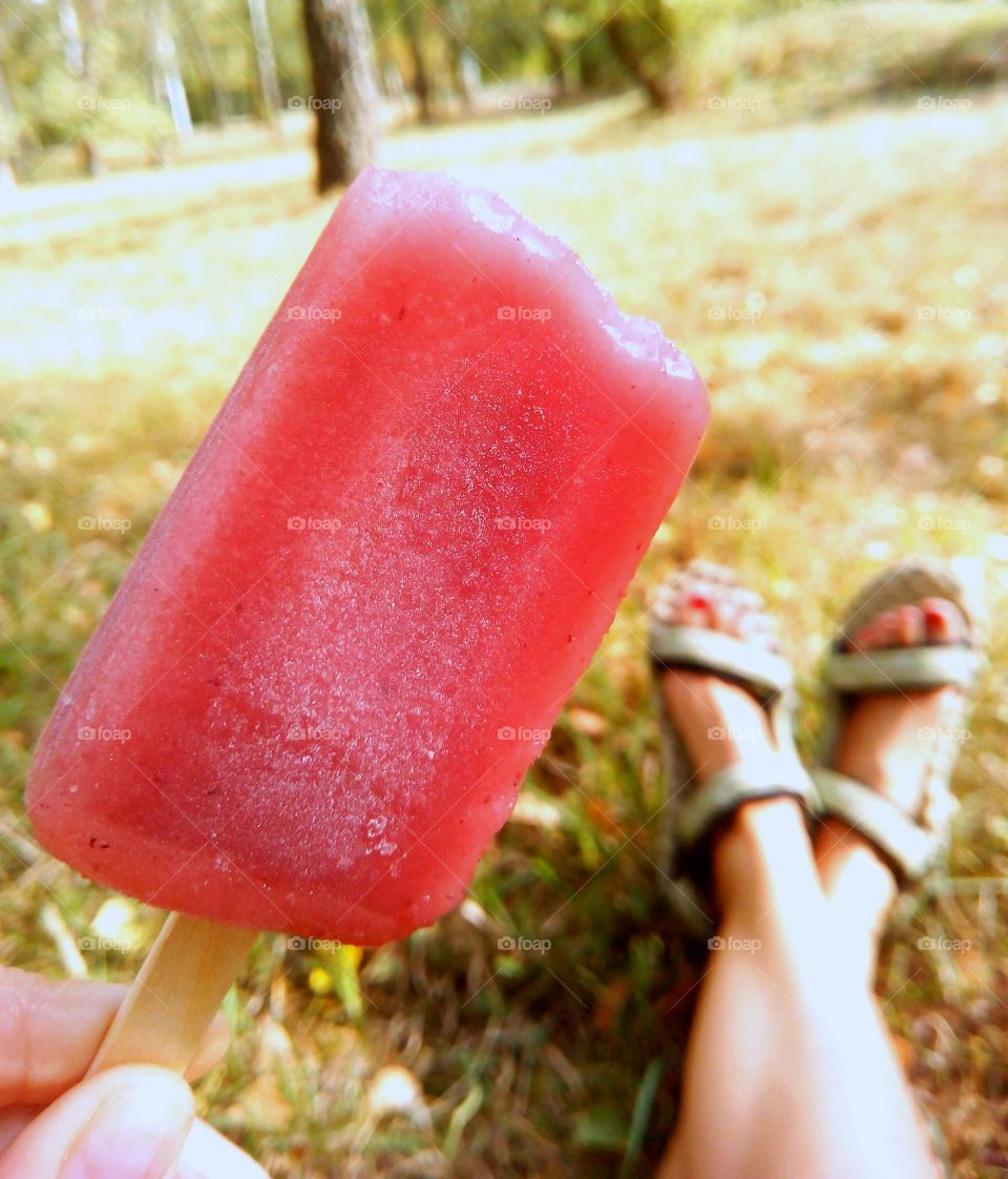 Ice cream eating in the park on a green grass