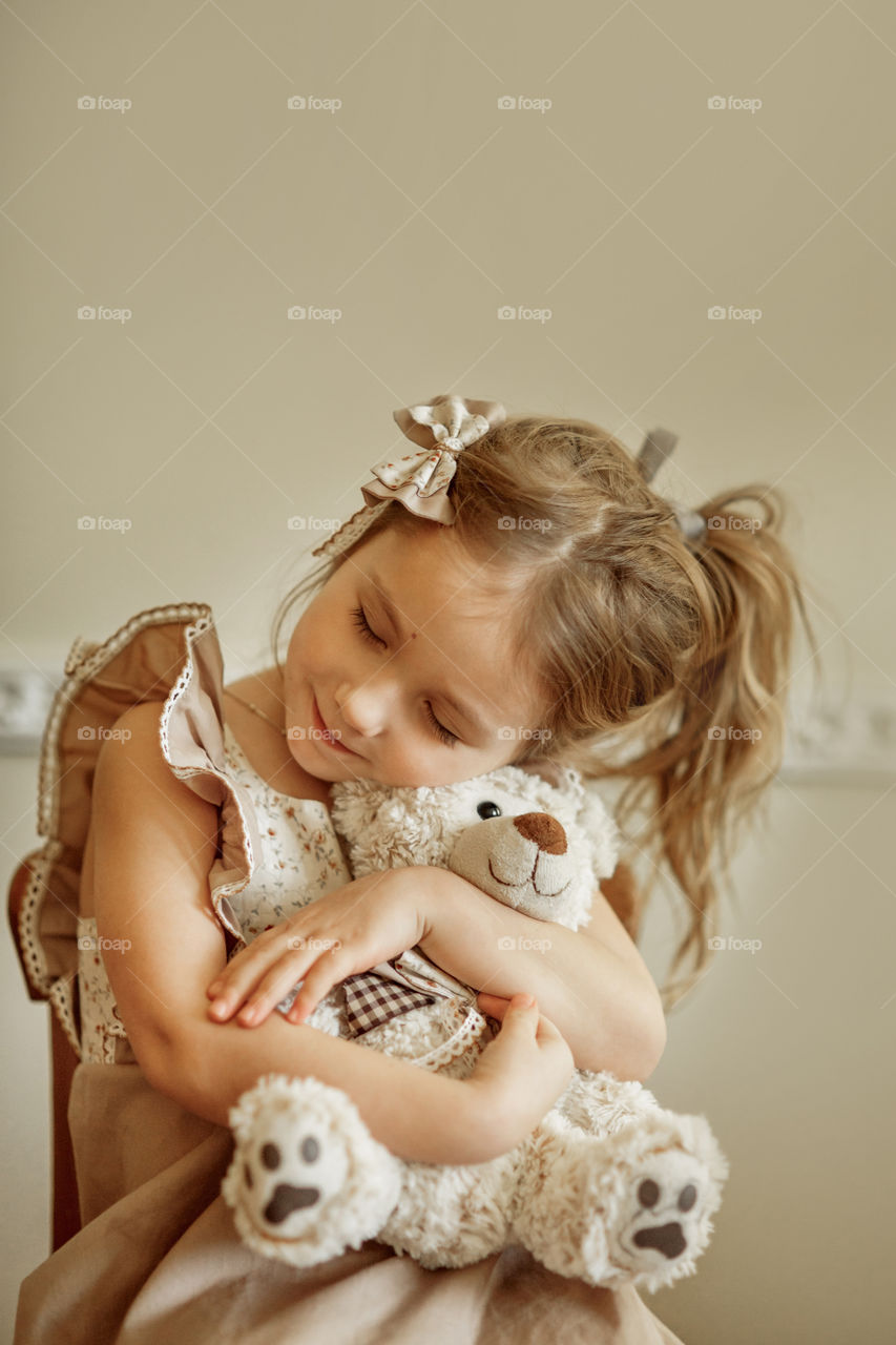 Vintage portrait of a beautiful little girl with teddy bear 